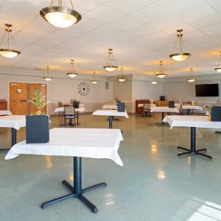A spacious dining area with neatly arranged tables, ready for guests.