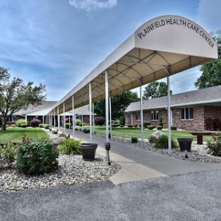 A well-maintained building with a walkway and landscaped garden under a clear blue sky.