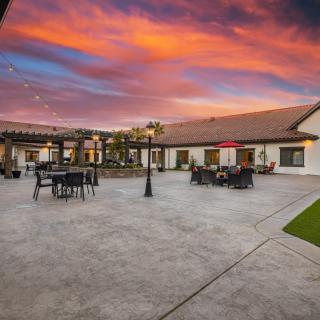 A beautiful courtyard at sunset with outdoor furniture and vibrant skies.