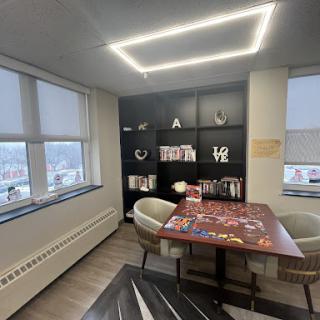A modern office space featuring a collaborative table and shelving, designed to foster creativity.