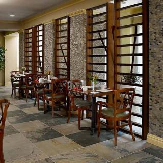 A modern dining area with neatly arranged tables and chairs, featuring chic interior design elements.