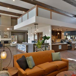 A modern open-concept living room with a kitchen and loft area.