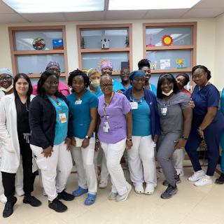 A dedicated team of healthcare professionals posing together in a hospital setting.