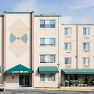 A four-story hotel building with green awnings and geometric designs on the facade.