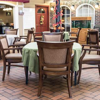 A cozy indoor dining area with multiple tables and chairs, decorated with green tablecloths.