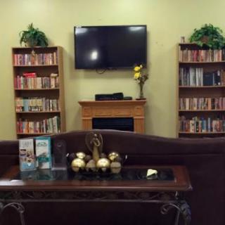A cozy living room with bookshelves, a television, and a decorative table.