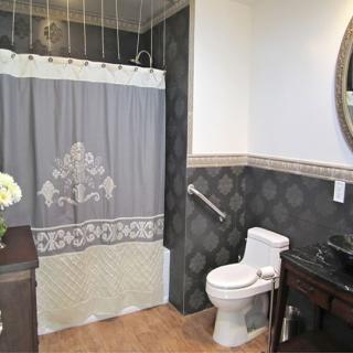 A well-decorated bathroom with a shower curtain, toilet, and sink with a mirror.