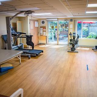 A well-lit exercise room equipped with a treadmill and stationary bike.