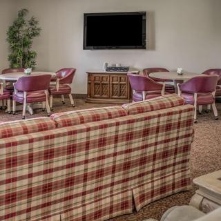 A cozy living room with plaid sofa and seating area featuring a television.