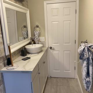 A modern bathroom with a vessel sink and decorative mirror.