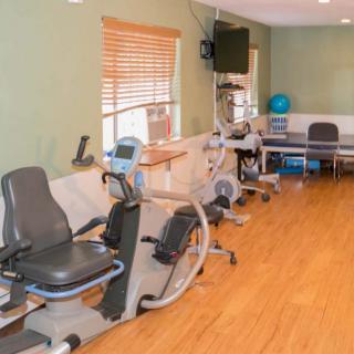 A fitness room equipped with exercise bikes and therapy equipment.