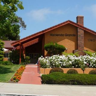 A well-maintained suburban dentist office with brick exterior and colorful landscaping.