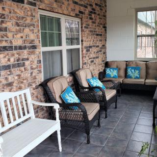 A cozy outdoor porch featuring inviting seating and colorful cushions.