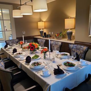 A beautifully set dining table prepared for a formal dinner with elegant decor and candles.