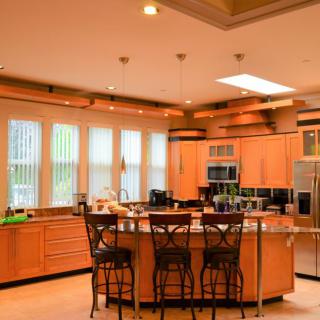 A modern kitchen with wooden cabinets and a central island equipped with stools.