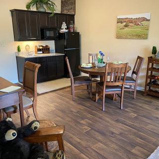 A cozy kitchen and dining area featuring wooden furniture and flooring, with modern appliances.