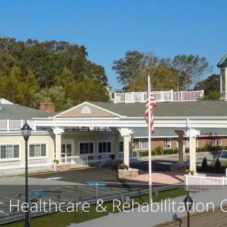 A healthcare and rehabilitation center surrounded by trees, featuring an American flag in front.