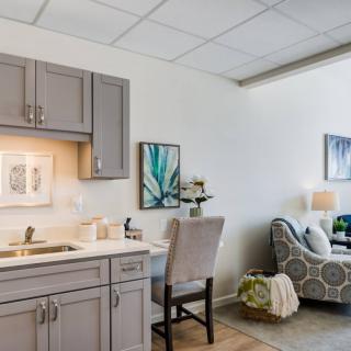 A cozy living space featuring a kitchenette and comfortable seating area with modern decor.