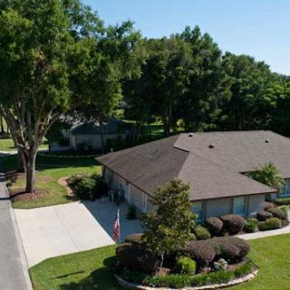 A picturesque view of a well-maintained residential home surrounded by lush greenery.