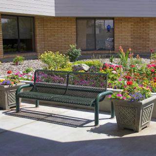 A serene outdoor space featuring a bench surrounded by vibrant flowers in a garden setting.