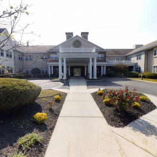 A symmetrical building entrance with a landscaped pathway leading up to it.