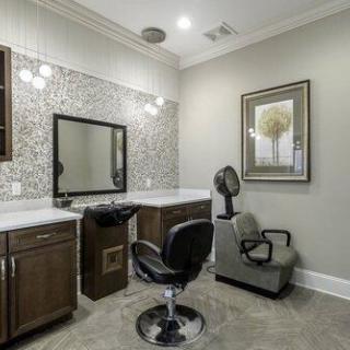 A well-decorated hair salon interior with chairs, mirrors, and stylish lighting.
