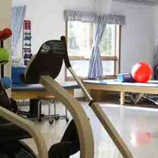 A glimpse of a fitness space equipped for rehabilitation, featuring exercise equipment and colorful exercise balls.