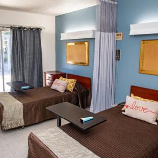 A cozy and well-decorated bedroom with twin beds and a blue accent wall.