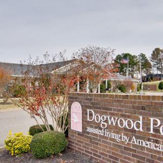 Entrance view of Dogwood Park with a prominent brick sign and surrounding greenery.
