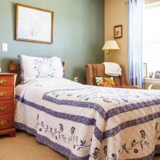 A cozy bedroom with a single bed adorned with a patterned quilt.