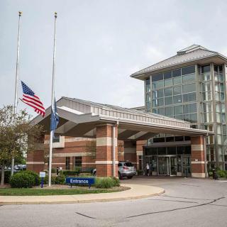 Entrance of a hospital with flags at half-mast.