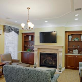 A cozy living room featuring a fireplace, modern furnishings, and built-in shelves.