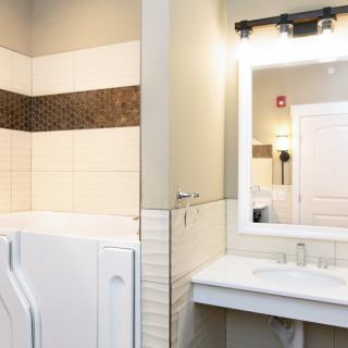 A modern bathroom with a washing machine and well-lit mirror.