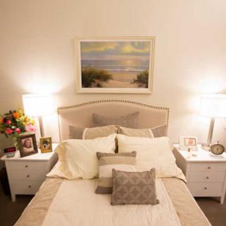 Cozy bedroom interior with a neatly made bed, bedside tables, and decorative lamps.