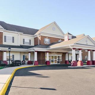 A two-story brick building with a prominent entrance and large windows.