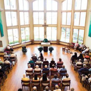 A community gathered for worship in a bright church interior.