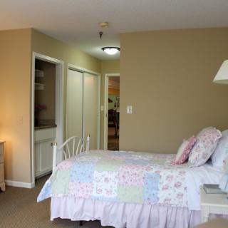 A cozy bedroom with pastel-colored bedding and simple decor.
