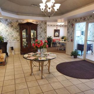 A cozy lobby area with elegant furniture, decorative plants, and warm lighting.