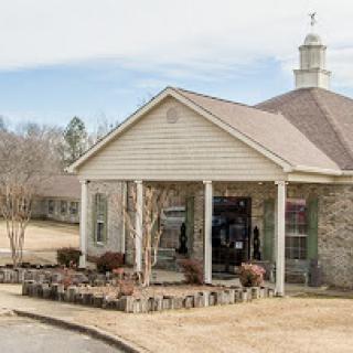 A charming building with a welcoming entrance, set in a serene landscape.