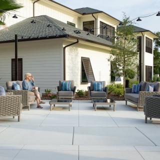 An inviting outdoor patio area with comfortable seating and a modern residential backdrop.