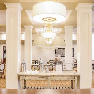 Elegant dining area with chandeliers and decorative pillars.