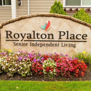Sign for Royalton Place Senior Independent Living with colorful flowers in front.