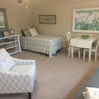 A cozy bedroom with a bed, table, and chairs, decorated in a neutral color palette.
