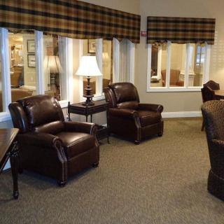 Cozy living room with leather chairs and warm lighting.