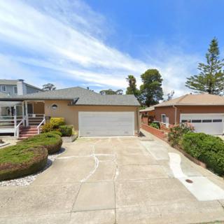 Suburban houses with driveways and garages under a clear blue sky.