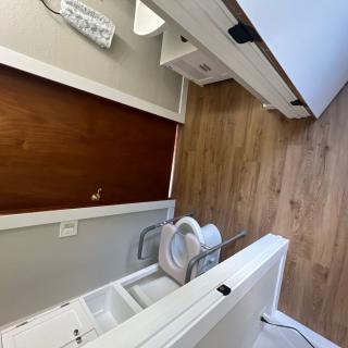 A modern bathroom with a wooden floor, featuring a sink and toilet.