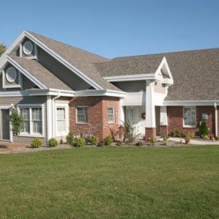 A suburban residential house with a brick exterior and a well-maintained lawn.