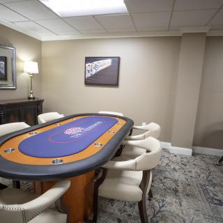 A luxurious game room featuring a poker table surrounded by comfortable chairs.