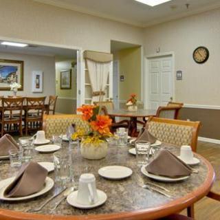 A cozy dining area with elegantly set tables and floral centerpieces.