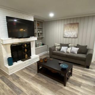 A modern living room with a sofa, coffee table, fireplace, and mounted television.